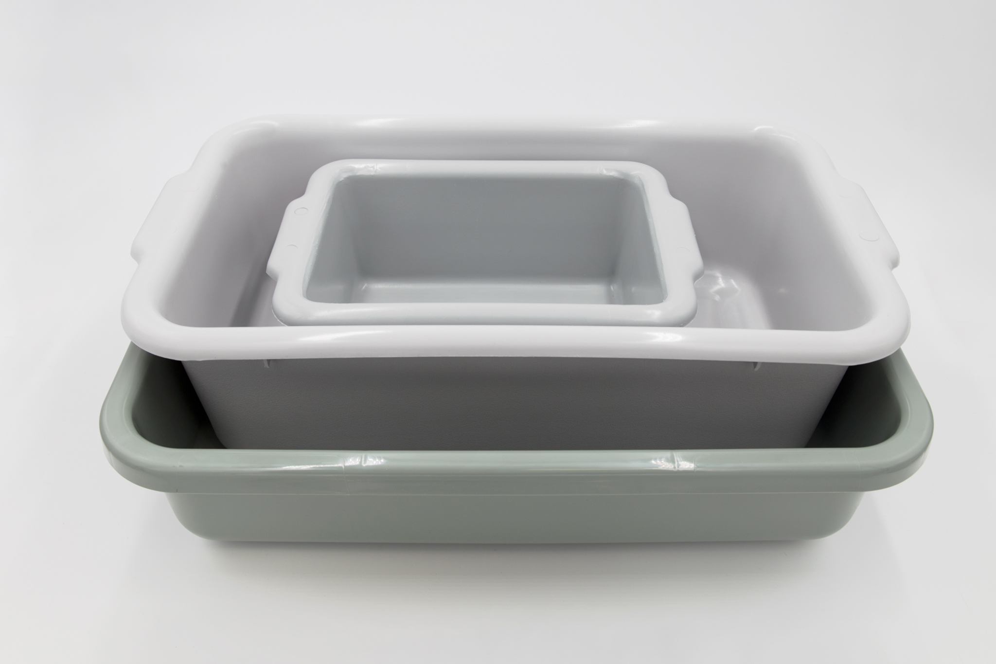 Stacked small, medium, and large gray spill trays on a white background.